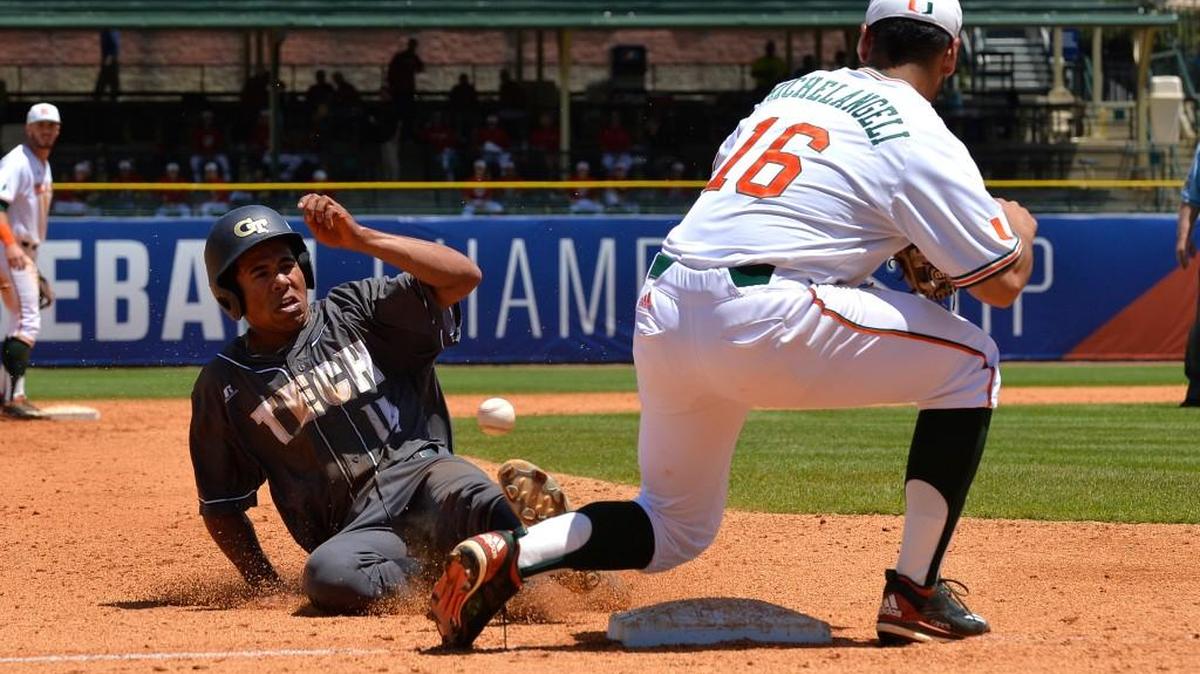 Georgia Tech's Austin Wilhite (14) slides into third ahead of an errant throw to Miami infielder Edgar Michelangeli (16) during their ACC Tournament game on Tuesday. Miami won 6-5 in 13 innings.