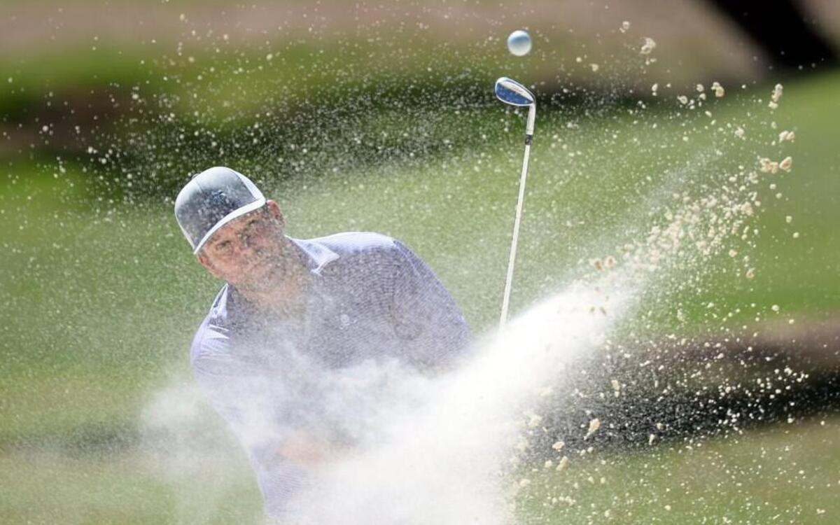 Stan Gann Jr. blasts from a trap to the fifth green during Sunday’s final round of the Peach Blossom golf tournament at Idle Hour Club.
