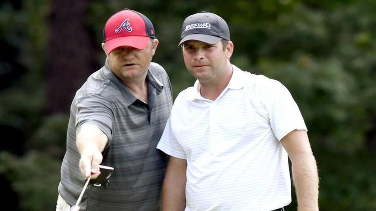 Shawn Hodge helps his playing partner Jon David Kennedy read a birdie putt on the par-4 15th hole at the Brickyard at Riverside during the final round of the Dixie Classic on Sunday.