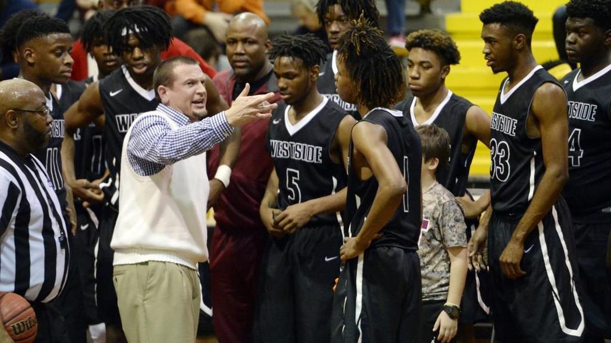 Westside Coach Josh Grube (left) takes a timeout to talk with his Seminoles after giving up a big lead early against Central on Friday.