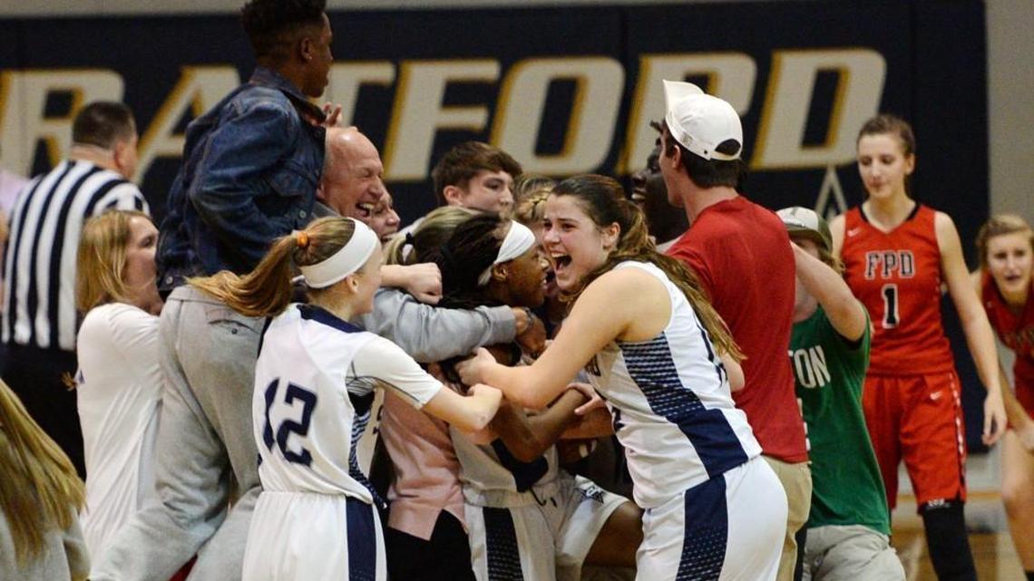Stratford's Nadia Reese (23) center is mobbed by her fans and teammates after her shot at the buzzer sank FPD. Stratford won the Region Championship beating FPD, 32-31.
