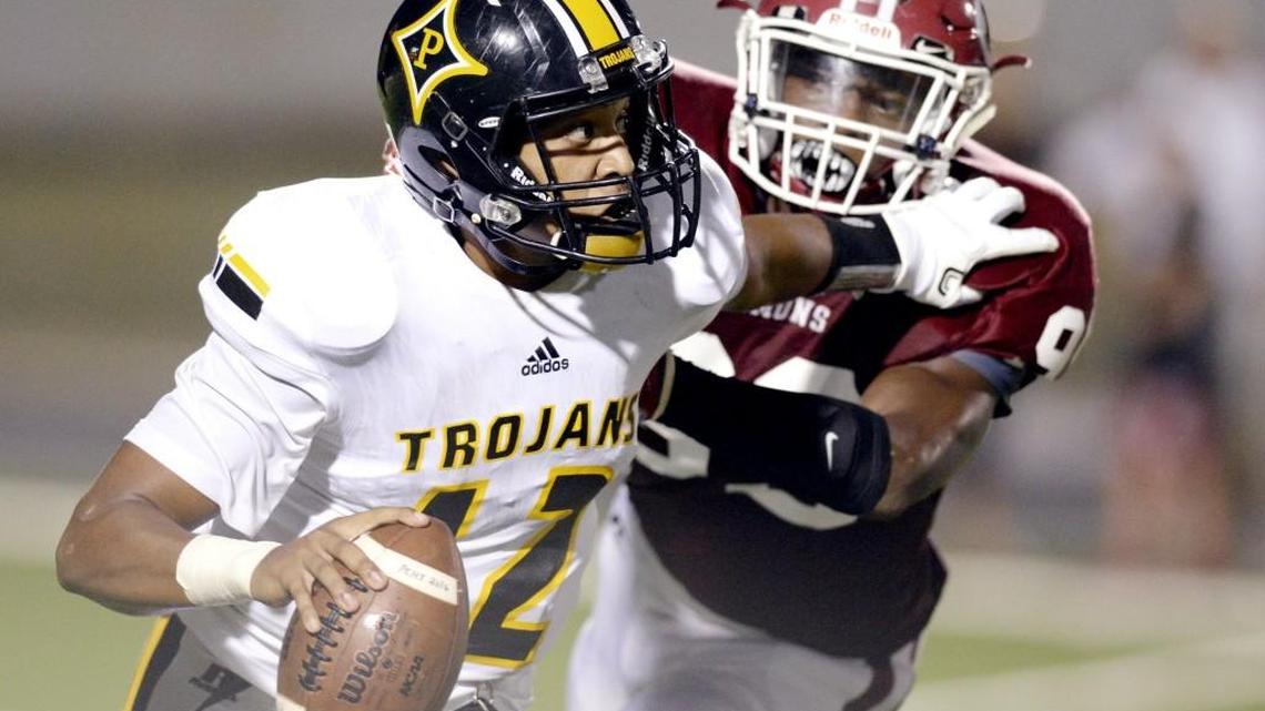 Peach County quarterback Antonio Gilbert (12) avoids a sack by Warner Robins' Bobby Kelly (99) during their game Sept. 2. The Trojans host Mary Persons on Friday.