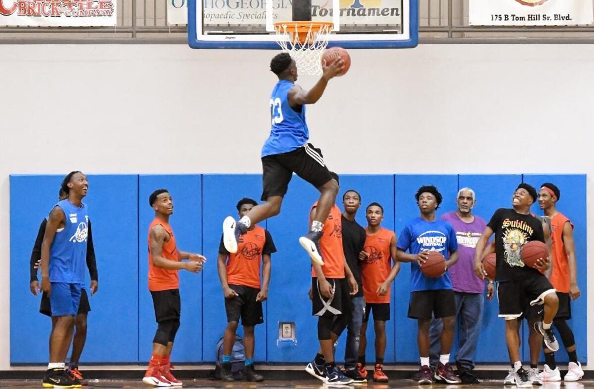 Fellow all-stars watch a 360 dunk attempt by Taylor County's Lyn-J Dixon (23) during the Middle Georgia All-Star Basketball Classic in March of 2017 at Tattnall Square Academy.