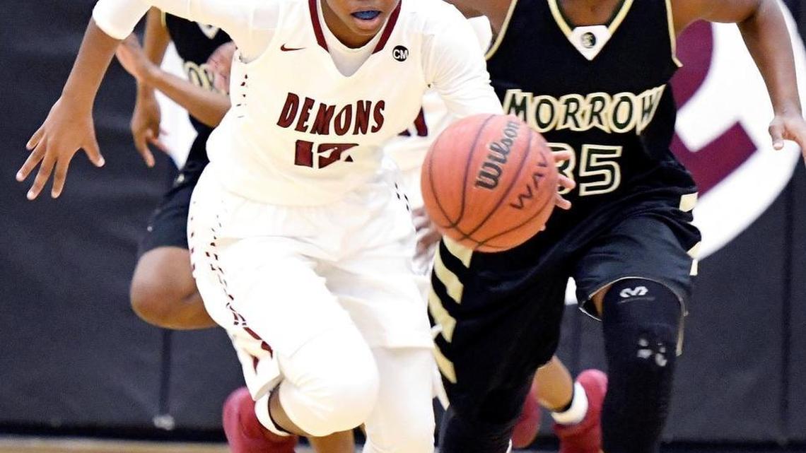 Warner Robins' Le'terria Mathis (12) drives the ball up court after stealing the ball during their first round playoff game against Morrow Friday night.