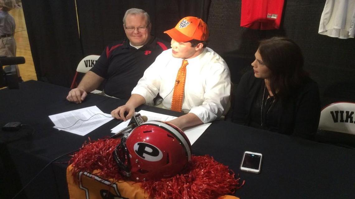 Flanked by his parents, Chris and Amy McBride, FPD center Thomas McBride talks with reporters following his National Signing Day Ceremony on Wednesday. McBride, a center, signed with Mercer.