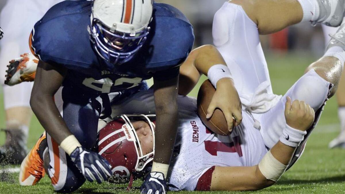 Northside defensive end Trashon Owens (93) rolls over Warner Robins quarterback Dalton Hedden with a sack.