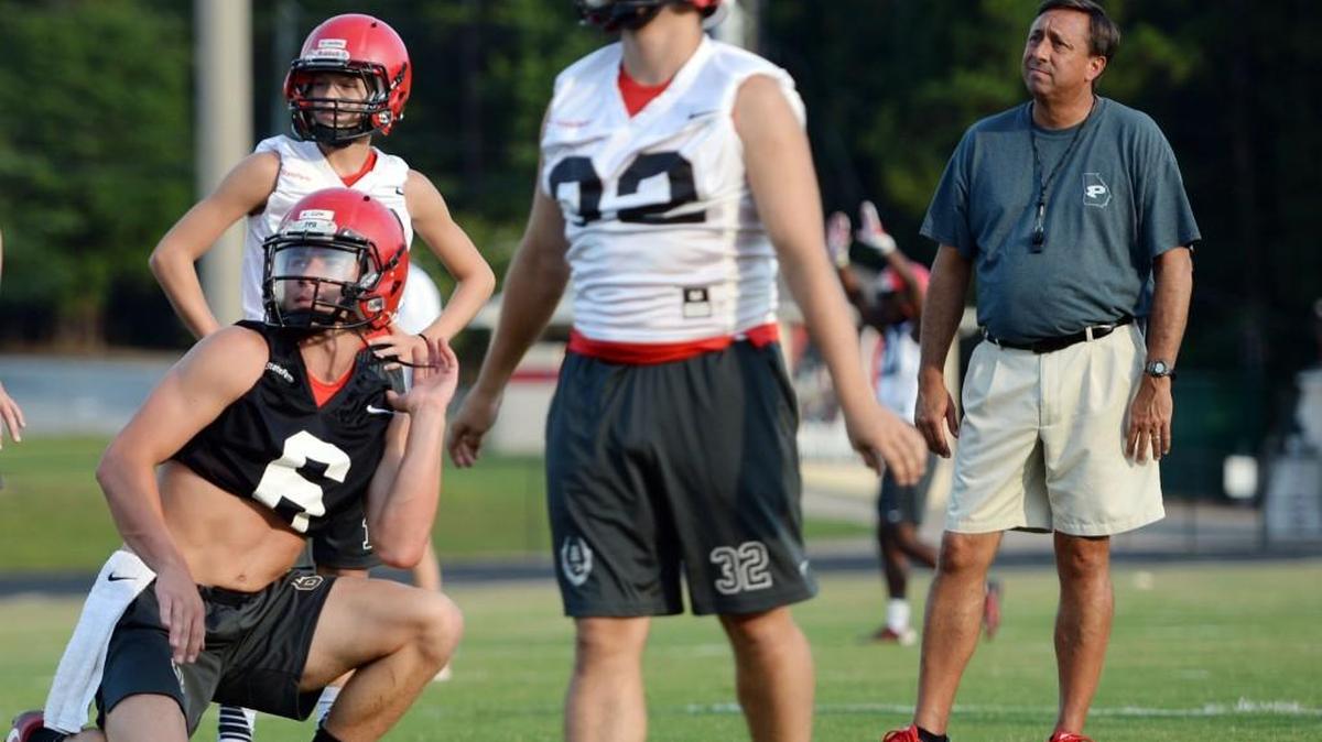 FPD coach Greg Moore, right, watches his place-kicking team during practice.