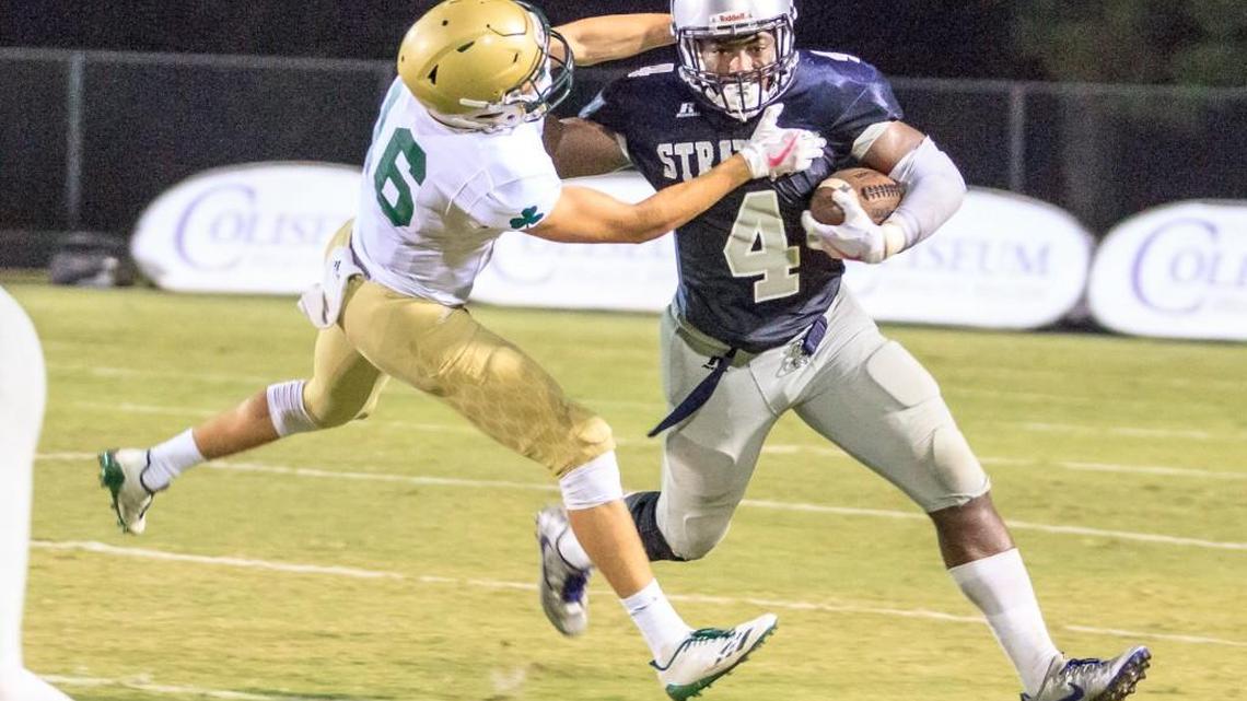 Stratford Academy’s Tyler Jordan (4) tries to avoid the tackle by Aquinas’s J.P. Lambert (16) during their game Friday night.