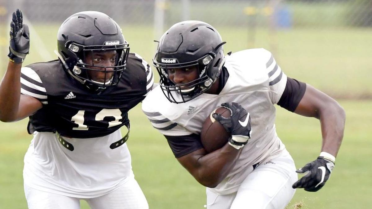 Peach County linebacker JaQuez Jackson, left, attempts to strip the ball from receiver Kearis Jackson during preseason practice.
