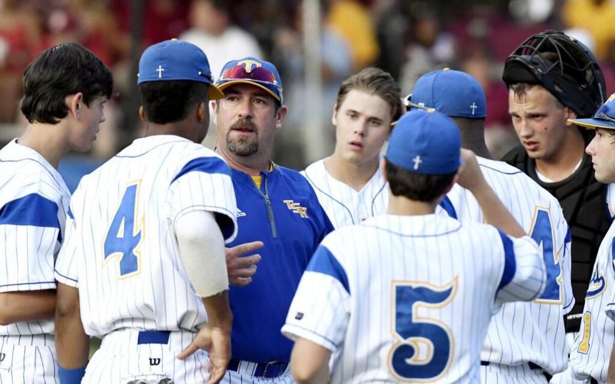 Head coach Joey Hiller, center, and the Tattnall Square Trojans are playing for the GHSA Class 1A private school baseball championship for the second year in a row.