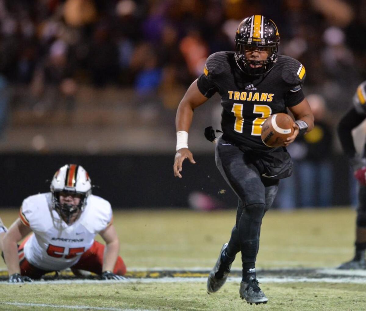 Peach County Trojan quarterback Antonio Gilbert slips away from a Greater Atlanta Christian defender and picks a first down late in the second half.