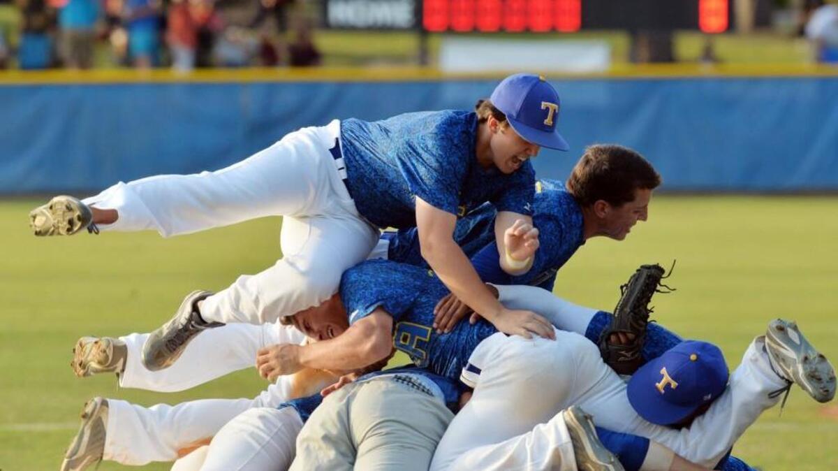 Tattnall Square players pile on their pitcher as they celebrate their GHSA Class A private championship win over Hebron Christian.