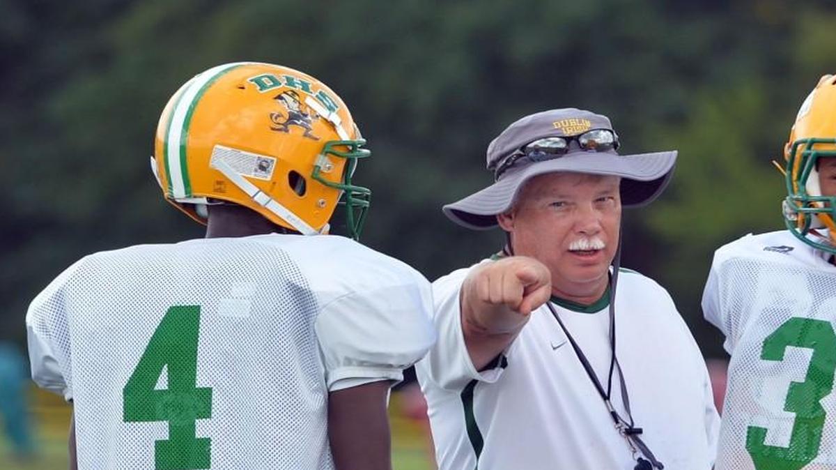 Dublin head coach Roger Holmes, center, works with running back Ramon Pittman (3) during a preseason practice.