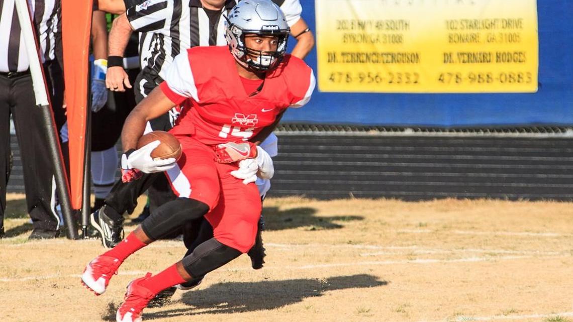 Eli Watson (14) of Houston County breaks a tackle for more yardage in the Middle Georgia All-Star Classic.
