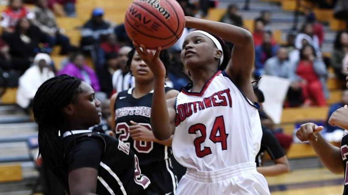 Westside's Naya Graham (25) draws a charge from Southwest's JaKaria Moore (24) during their game Tuesday night.