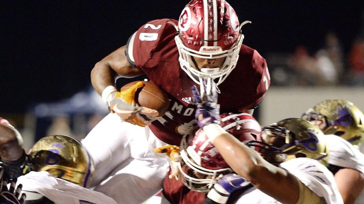 Warner Robins running back Jarius Burnette (20) leaps over Bainbridge defenders for a touchdown during their game Friday night.