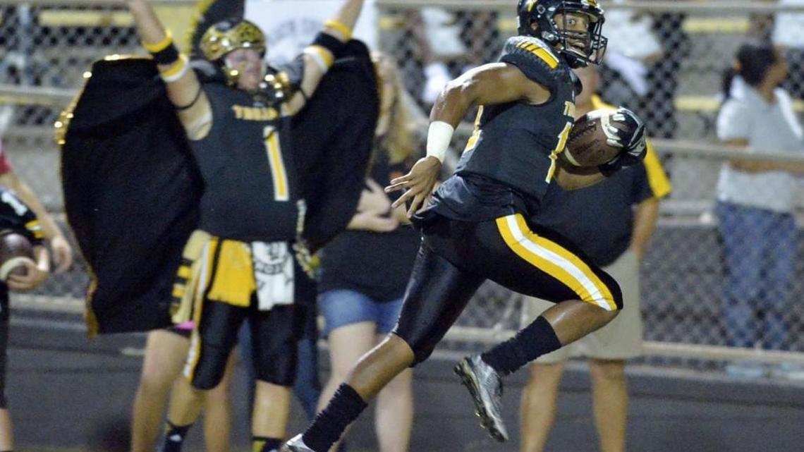Peach County quarterback Antonio Gilbert (12) heads for he end zone on a long touchdown run in the first half giving the Trojans a 17-0 lead.