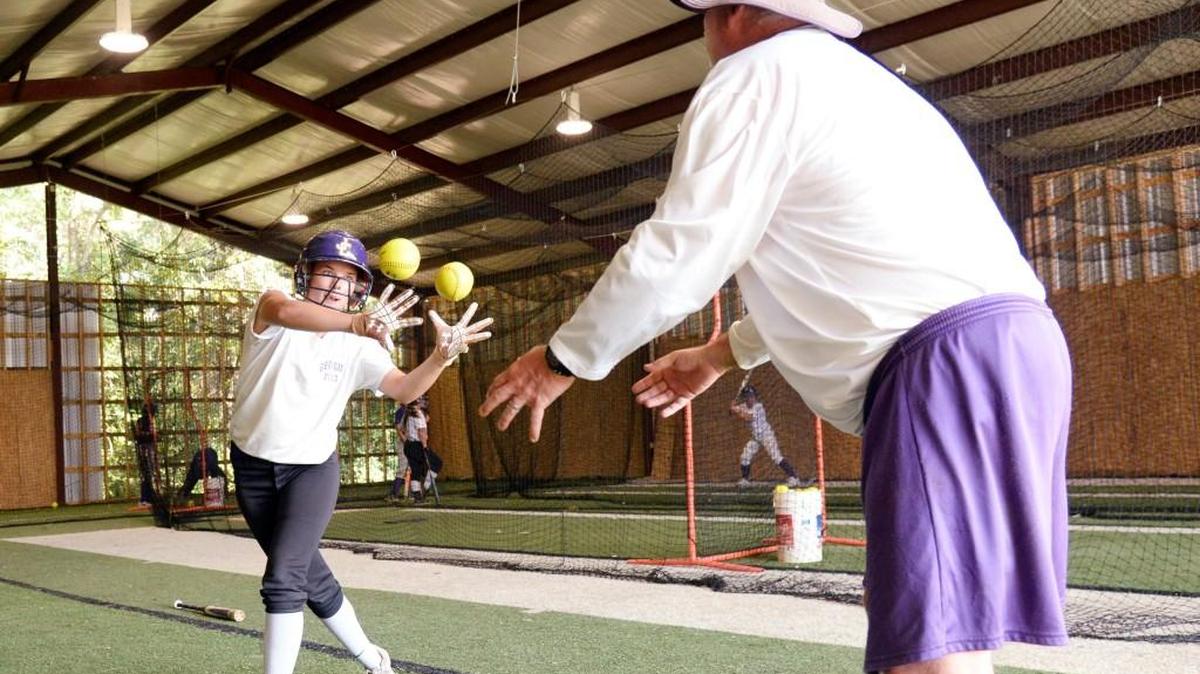 Jones County head coach Blake Lyons tosses balls to senior center fielder Shelby Fontenot during a drill at practice Tuesday afternoon.