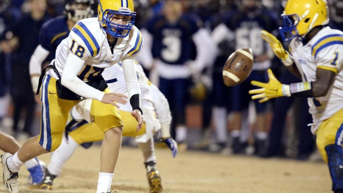 Tattnall quarterback Miles Morris (18) tosses the ball to running back Ahmad Barron (1) during their GHSA Class 1A private school semifinal game at Eagle's Landing Christian Friday night in McDonough.