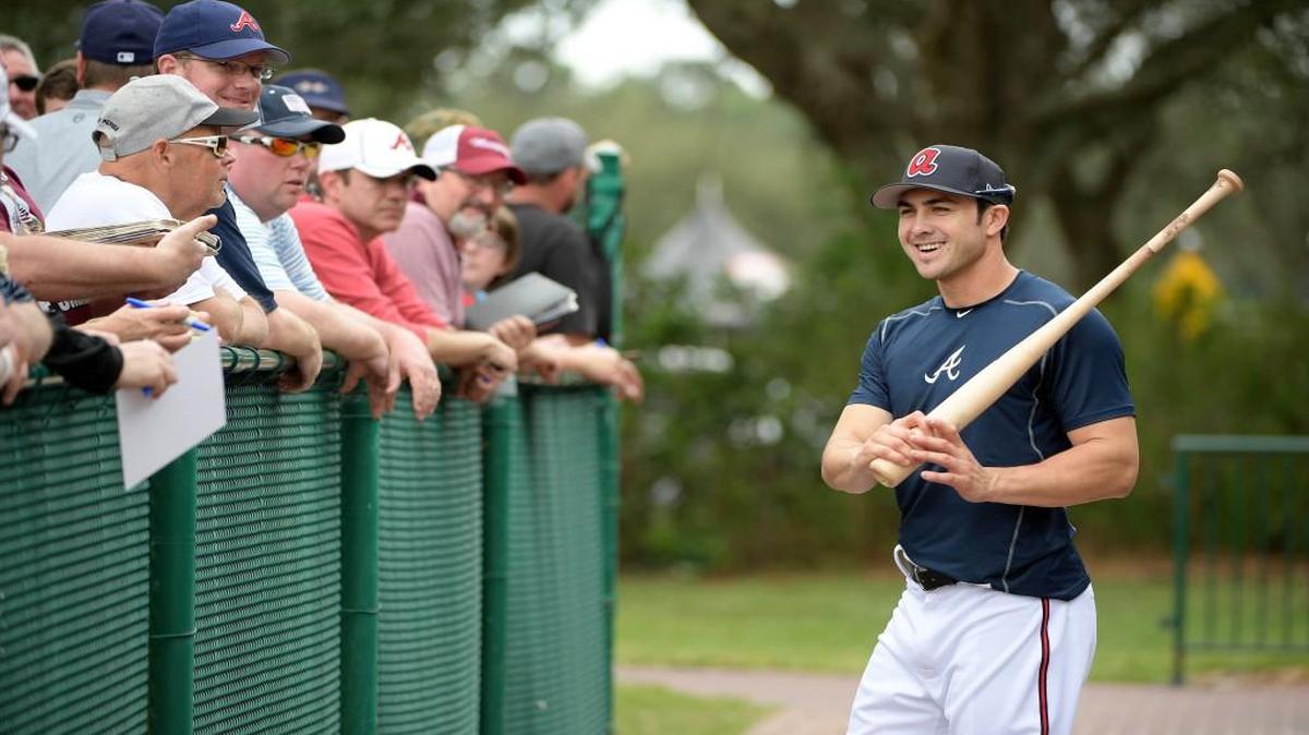 Atlanta Braves infielder Chase D’Arnaud talks with fans after hitting in the batting cages during the first full-squad spring training workout in Lake Buena Vista, Fla., Saturday, Feb. 18.
