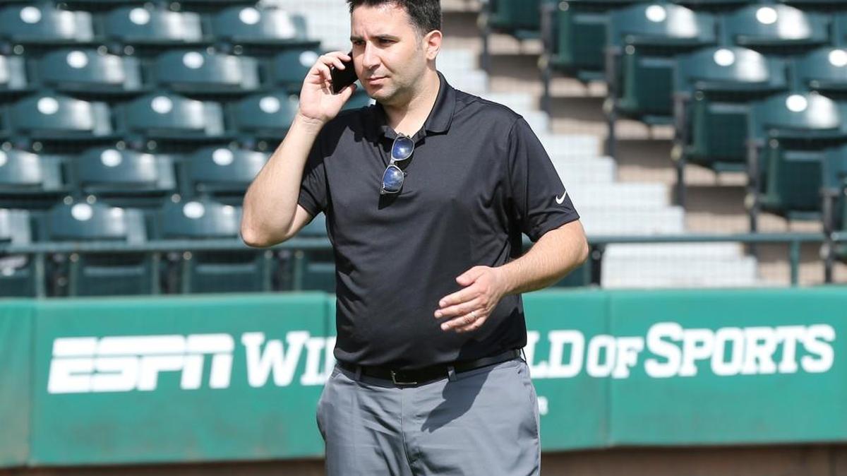 Atlanta Braves general manager Alex Anthopoulos works the phone minutes before announcing the team signed veteran catcher Chris Stewart to a one-year major league contract, a non-guaranteed deal that provides the team with more depth at a key position in case of injury, as pitchers and catchers hold their first workout at Champion Stadium on Feb 14 in Kissimmee, Fla.