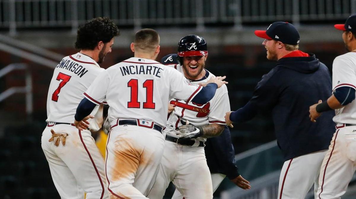 Atlanta Braves first baseman Matt Adams, center, is mobbed by his teammates after driving in the game-winning run with a single in the ninth inning Wednesday against Pittsburgh.