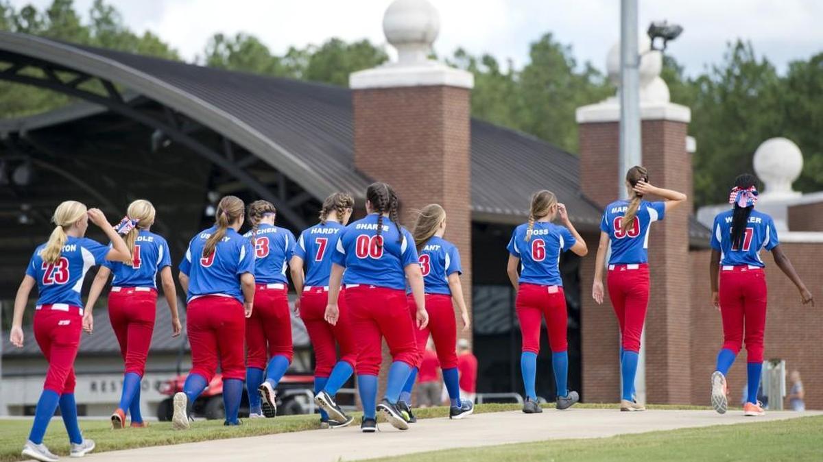 Members of the Western Little League softball team walk back to the field at the Southeastern Region Headquarters after having their photographs taken Wednesday.