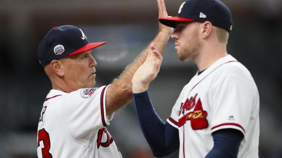 Atlanta Braves manager Brian Snitker, left, celebrates with Freddie Freeman at the conclusion of the second game of a baseball doubleheader against the Texas Rangers, Wednesday, Sept. 6, 2017, in Atlanta. The Braves won 5-4.