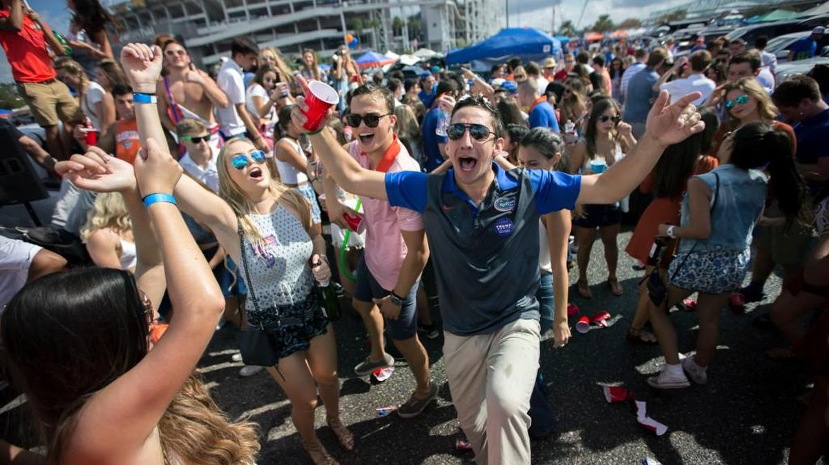 Florida students Tommy Chirigco, center, dances while tailgating in the parking lot of EverBank Field before the start of an NCAA football game between Florida and Georgia, Saturday, Oct. 29, 2016, in Jacksonville, Fla.
