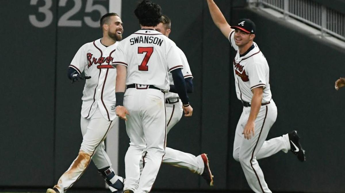 Atlanta Braves center fielder Ender Inciarte, left, Dansby Swanson (7) and Jesse Biddle, right, celebrate Inciarte's winning bunt during the ninth inning their game against the New York Mets on Saturday in Atlanta.