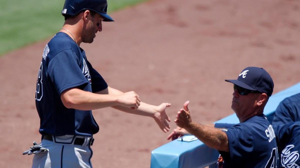 Atlanta’s Jeff Francoeur, left, is congratulated by interim manager Brian Snitker after scoring on a single by Nick Markakis during the first inning the Braves’ game against the Los Angeles Dodgers on Sunday.