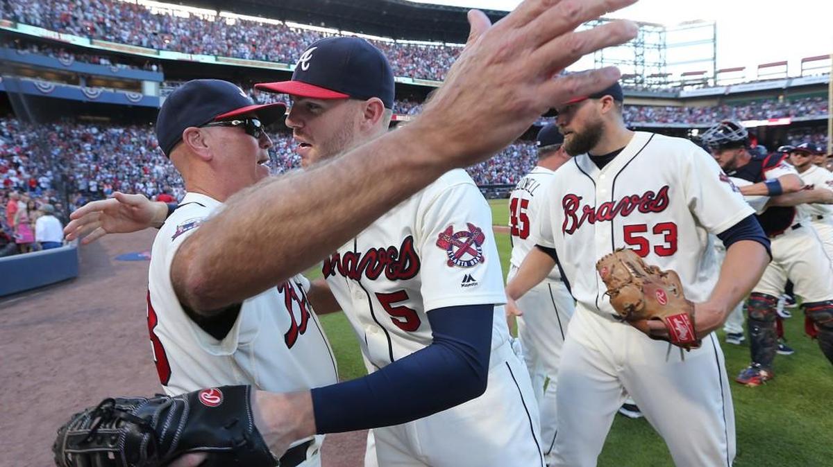 Atlanta Braves manager Brian Snitker, Freddie Freeman and the team celebrate beating the Detroit Tigers 1-0 on Sunday.