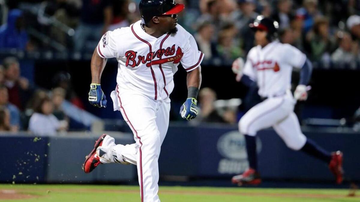 Atlanta Braves' Adonis Garcia, left, singles to score teammate Mallex Smith, rear right, in the sixth inning of a baseball game against the Arizona Diamondbacks on Friday in Atlanta.