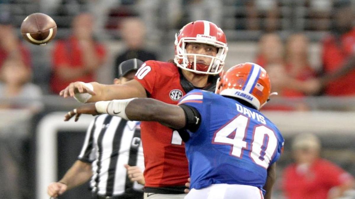 Georgia quarterback Jacob Eason (10) throws downfield while being pressured by Florida linebacker Jarrad Davis (40) during their game Saturday in Jacksonville.