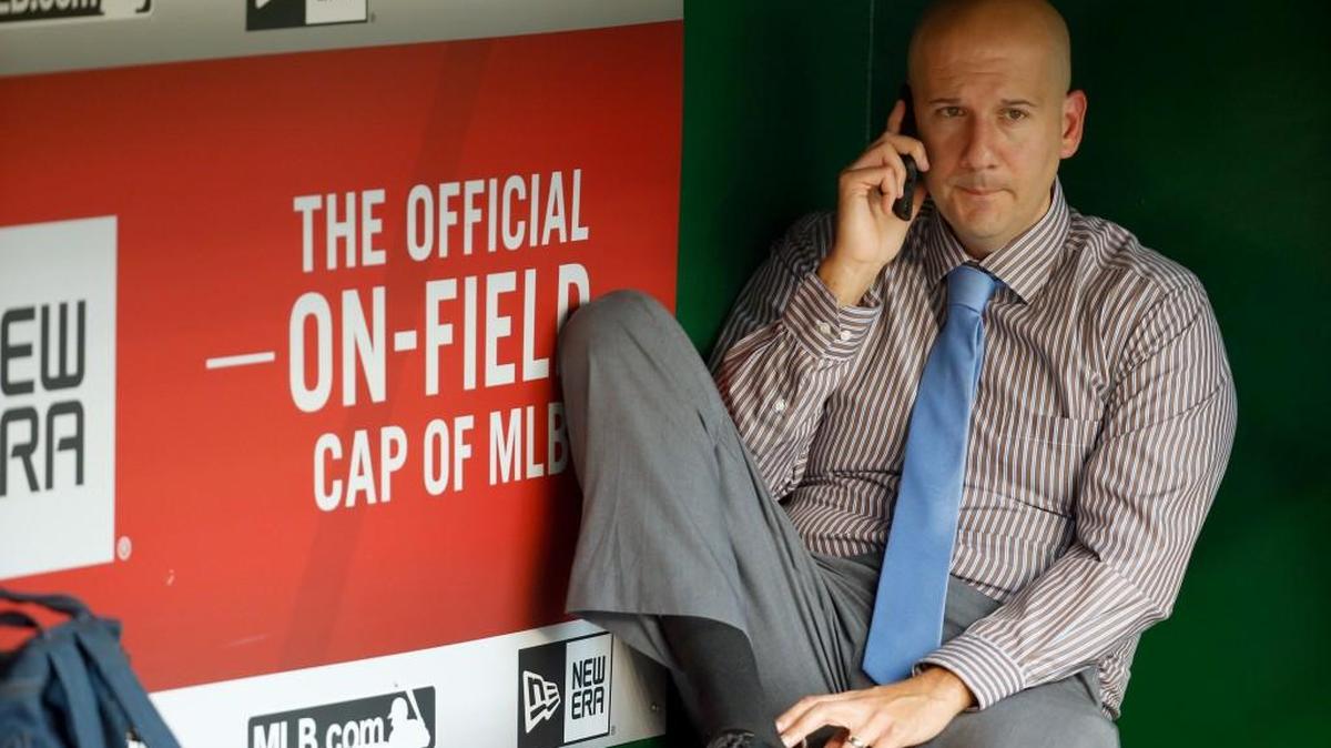 Atlanta Braves assistant general manager and director of pro scouting John Coppolella talks on the phone in the dugout during batting practice before a game against the Washington Nationals.