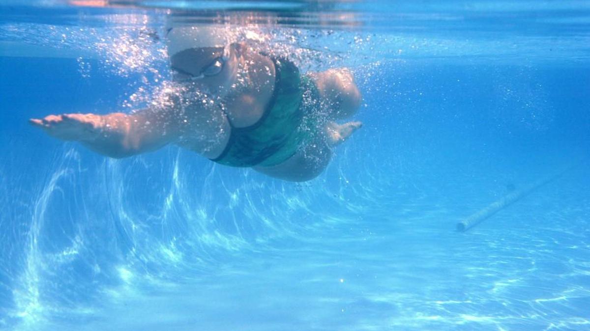 Angel Martino, now known as Angel McGuire, swims in her 50-foot Speedo training pool in Milledgeville in 2000.