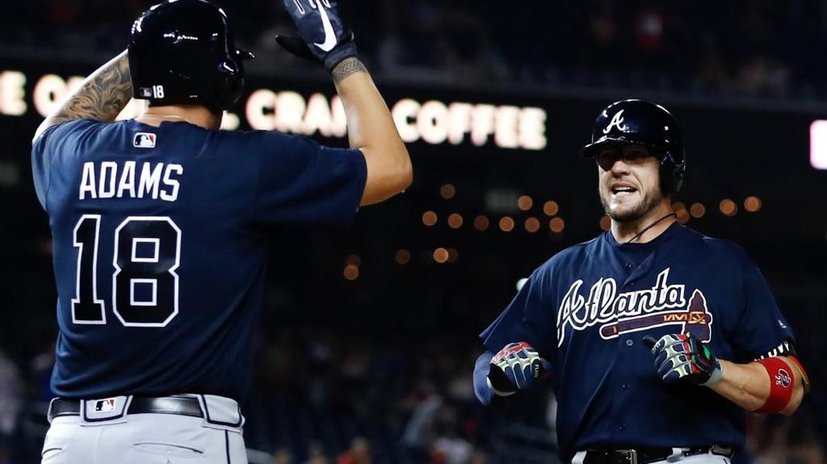 Atlanta Braves catcher Tyler Flowers (25) crosses the plate to celebrate with teammate Matt Adams after hitting the go-ahead home run against Washington on Monday.