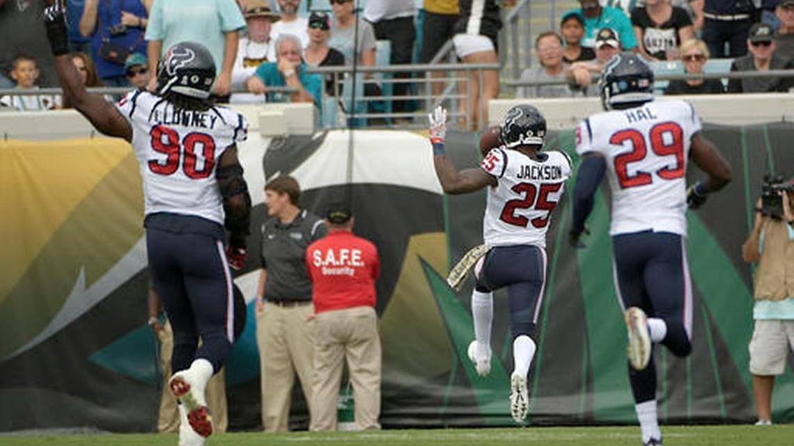 Houston Texans cornerback Kareem Jackson (25) runs for a 42-yard touchdown on a Jacksonville Jaguars interception as defensive end Jadeveon Clowney (90) and free safety Andre Hal (29) celebrate during the first half of an NFL football game in Jacksonville, Fla., Sunday, Nov. 13, 2016.