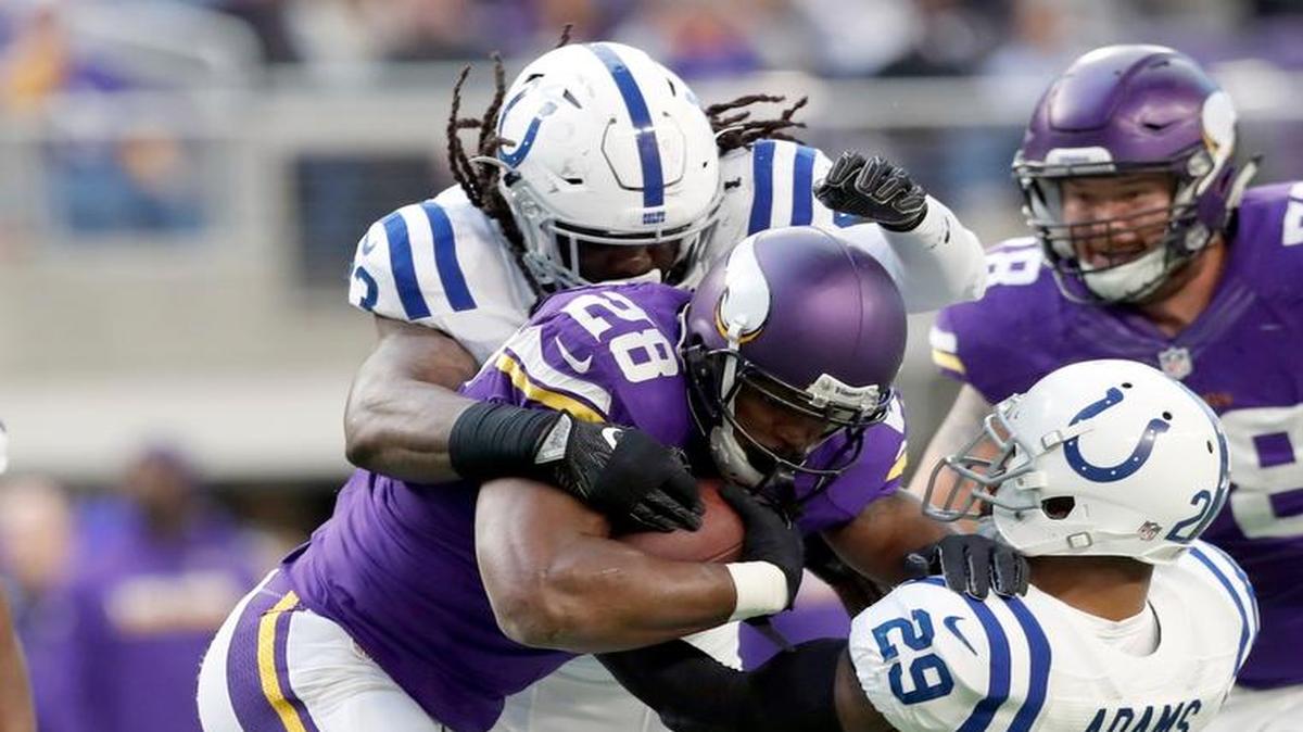 Minnesota Vikings running back Adrian Peterson (28) runs with the ball as Indianapolis Colts linebacker Erik Walden and safety Mike Adams (29)defend during the first half of an NFL football game Sunday, Dec. 18, 2016, in Minneapolis.