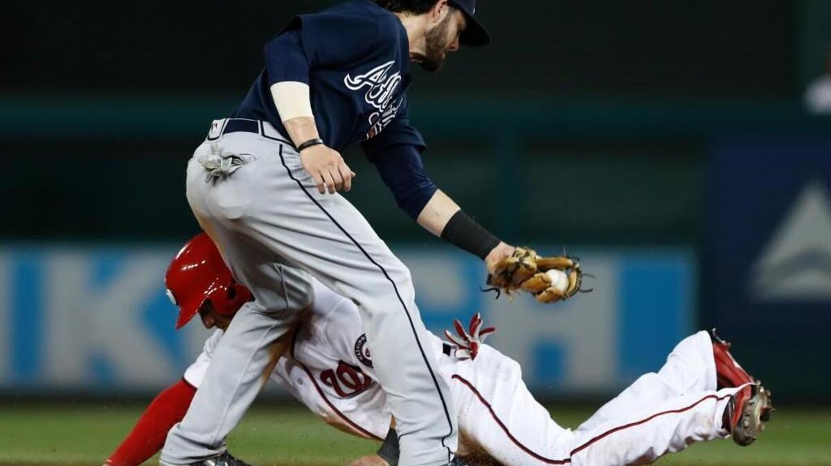 Atlanta Braves shortstop Dansby Swanson is late with the tag as Washington’s Ryan Raburn is safe at second Tuesday.