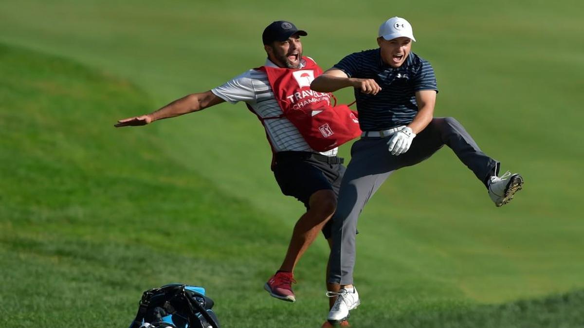 Jordan Spieth, right, celebrates with caddie Michael Greller after Spieth holed a bunker shot on a playoff hole on the 18th hole to win the Travelers Championship golf tournament Sunday, June 25, 2017, in Cromwell, Conn.