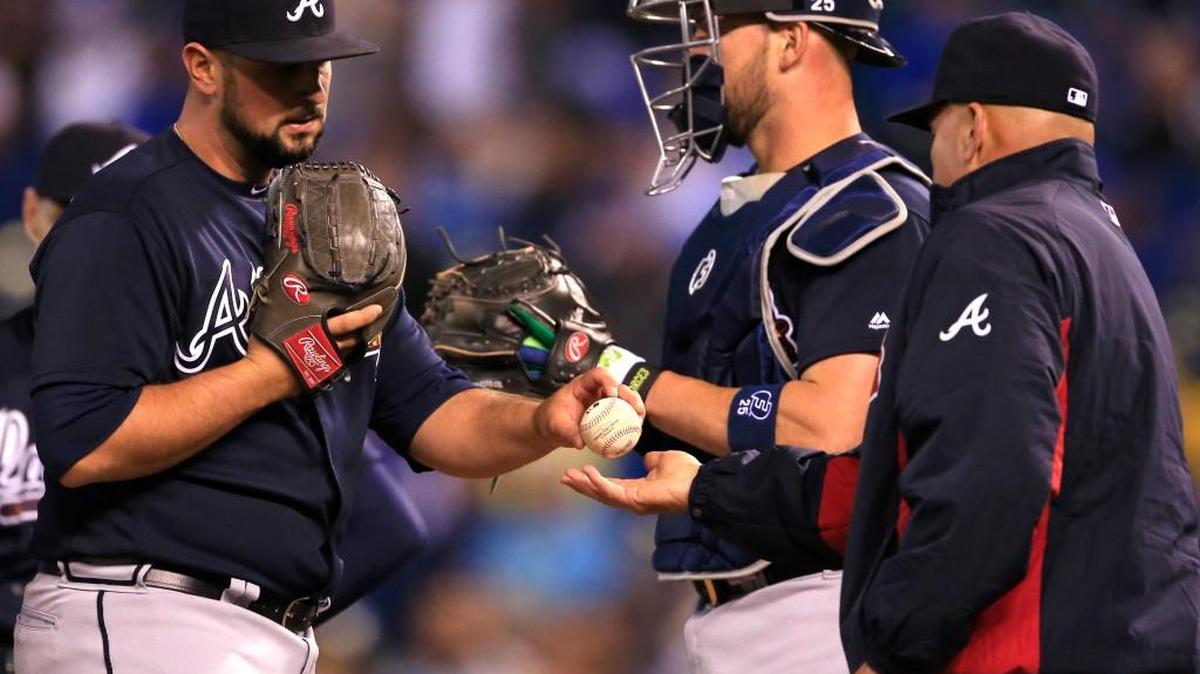 Atlanta manager Fredi Gonzalez, right, takes the ball from relief pitcher Hunter Cervenka, left, during the eighth inning of Friday’s game.