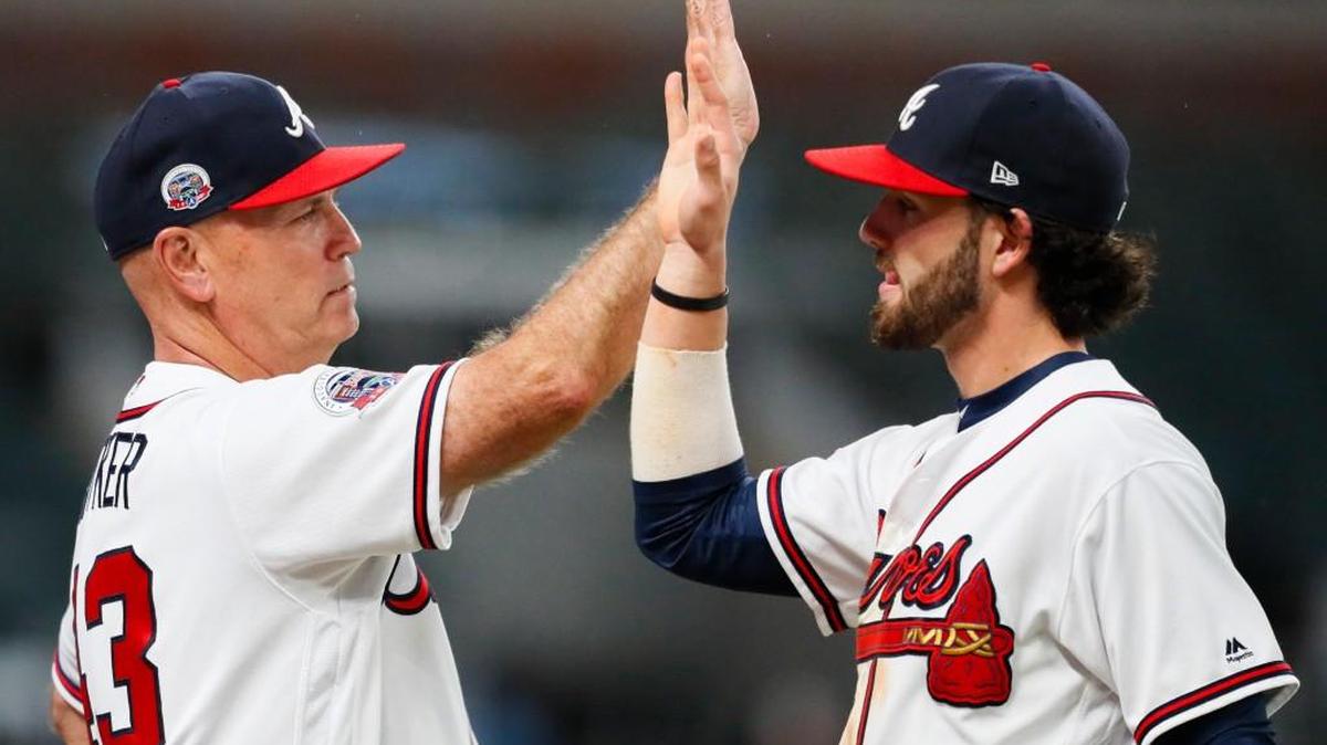 Atlanta Braves manager Brian Snitker (43) celebrates the victory with shortstop Dansby Swanson after the team's win over Philadelphia on Wednesday.