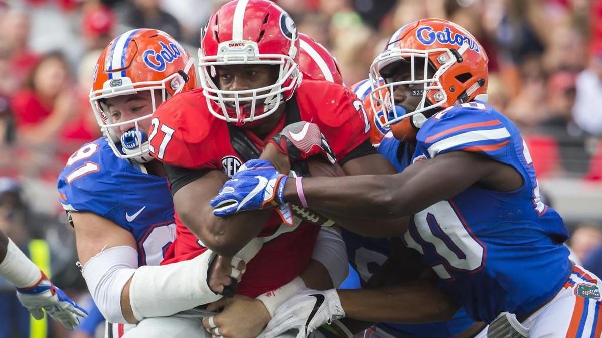 Florida defensive back Marcus Maye (20) and Florida defensive lineman Joey Ivie (91) tackle Georgia running back Nick Chubb (27) during the 2016 Georgia-Florida game.
