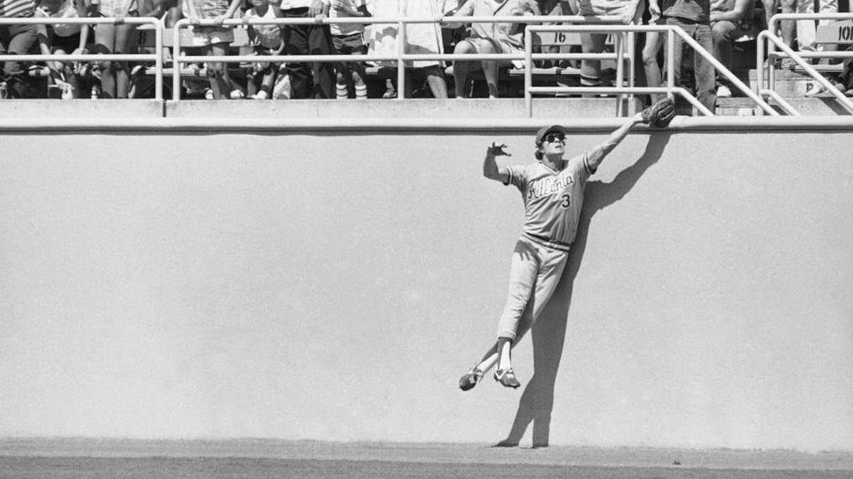 An archival photo of Atlanta Braves center fielder Dale Murphy leaping high against the wall in center field at Dodger Stadium to catch a fly ball hit by Pedro Guerrero.