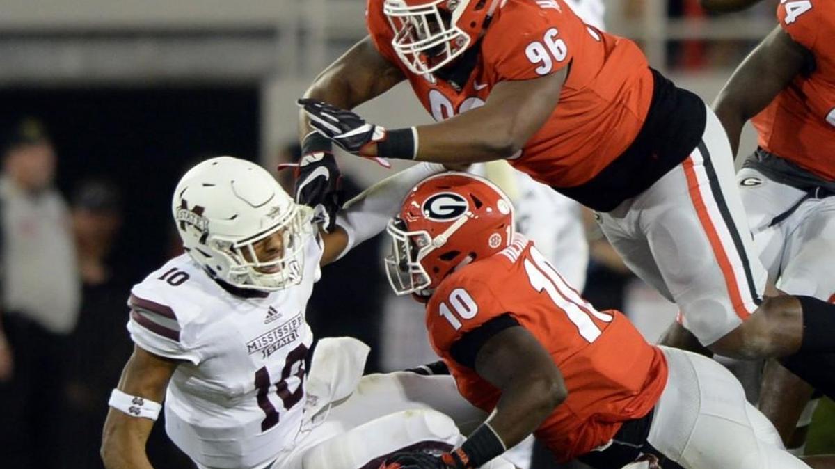 Georgia defensive tackle DaQuan Hawkins-Muckle (96) and lineman Malik Herring (10) put Mississippi State quarterback Keytaon Thompson (10) on his back after he cut loose with a pass. Georgia beat Mississippi State, 31-3.
