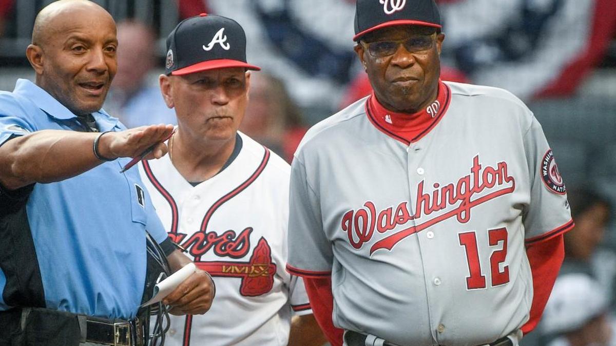 Washington Nationals manager Dusty Baker (12) and Atlanta Braves manager Brian Snitker meet with umpire C.B. Bucknor before a baseball game Tuesday, April 18, 2017, in Atlanta.