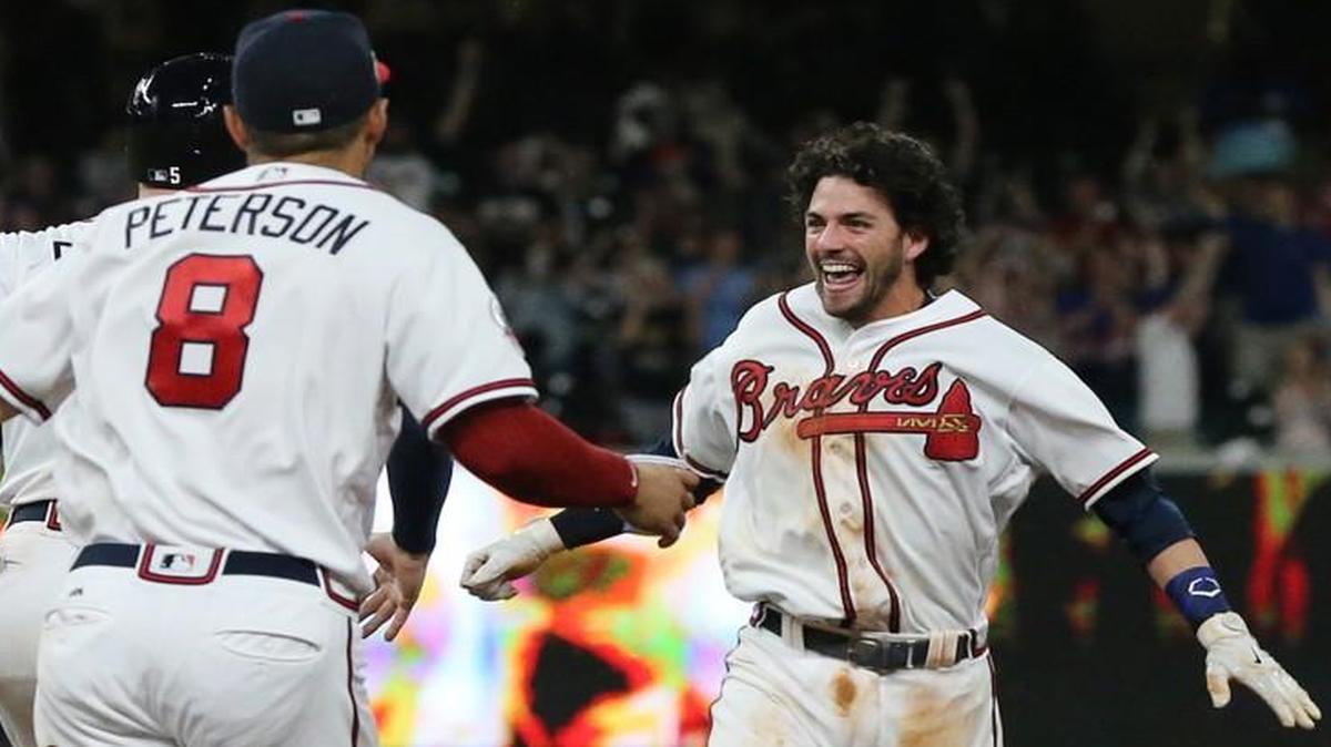 The Atlanta Braves rush the field to mob Dansby Swanson as he hits a walk off single to beat the San Diego Padres 5-4 during the ninth inning on Monday, April 17, 2017 in Atlanta.