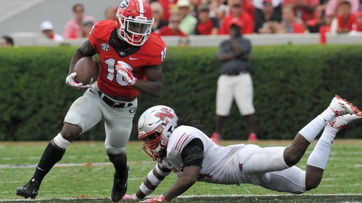 Georgia’s Isaiah McKenzie slips a tackle and heads to the end zone for a touchdown against Nicholls State on Saturday in Athens.