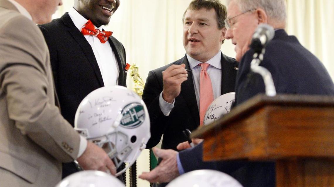 Georgia coach Kirby Smart signs football helmets and visits with Georgia signee Malik Herring during the Macon Touchdown Club meeting Monday.